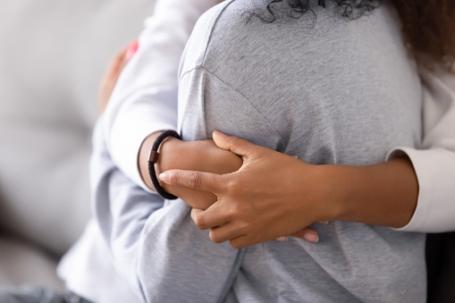 Loving african american foster care parent single mother sister embrace teen daughter giving support and protection, black mom hug teenage girl, family kindness concept, close up view, focus on hands