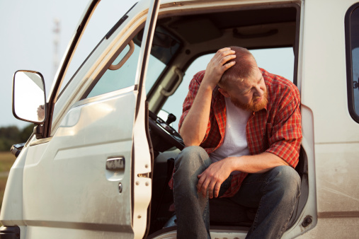 Driver of the car is sitting thinking about something