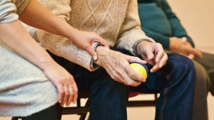 A person sitting between two people holding a stressball.