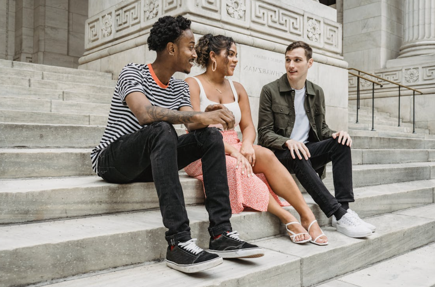 Three people sitting on the steps at a university