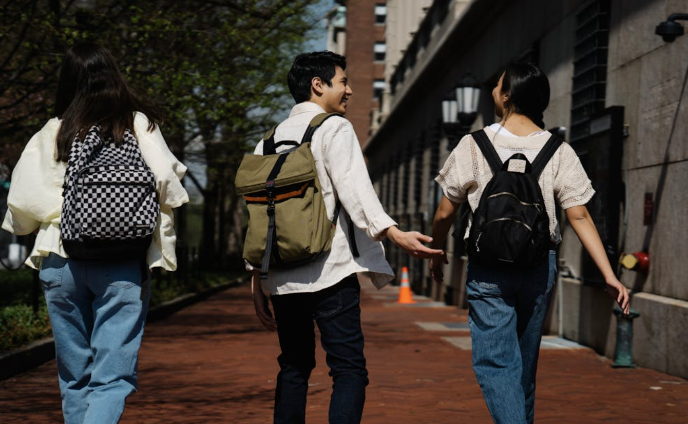Three students walking around campus after class