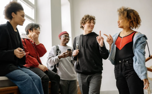 A group of classmates talking to each other in the hallway.