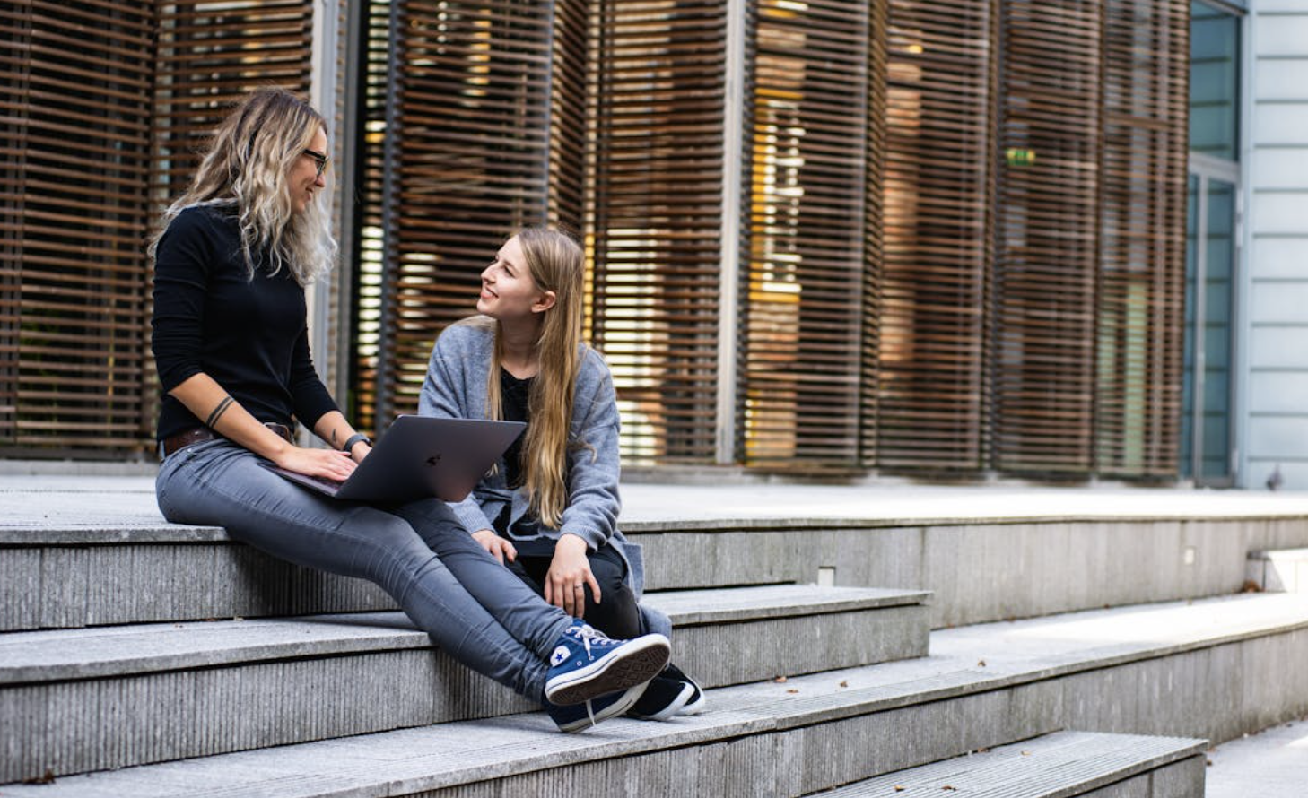 Two students sitting down on the stairs and talking.
