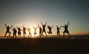 A group of people jumping, silhouetted against the sky