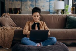 Woman sits against a brown couch looking