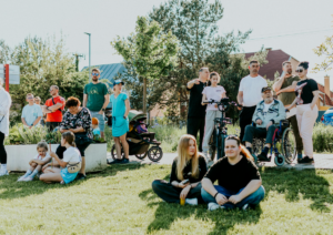 A large group of people gathers on a grassy lawn