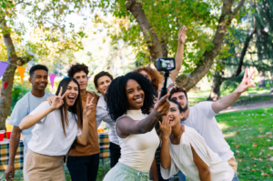 Student take a group selfie together outdoors at a campus picnic