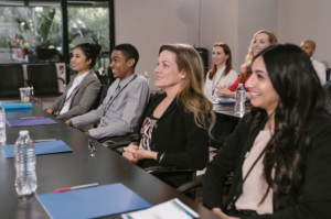 People sit in conference seating and smile