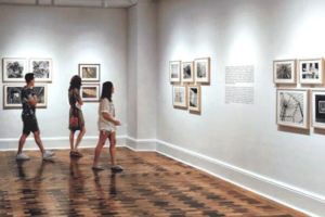 People walk around a well-lit open gallery space