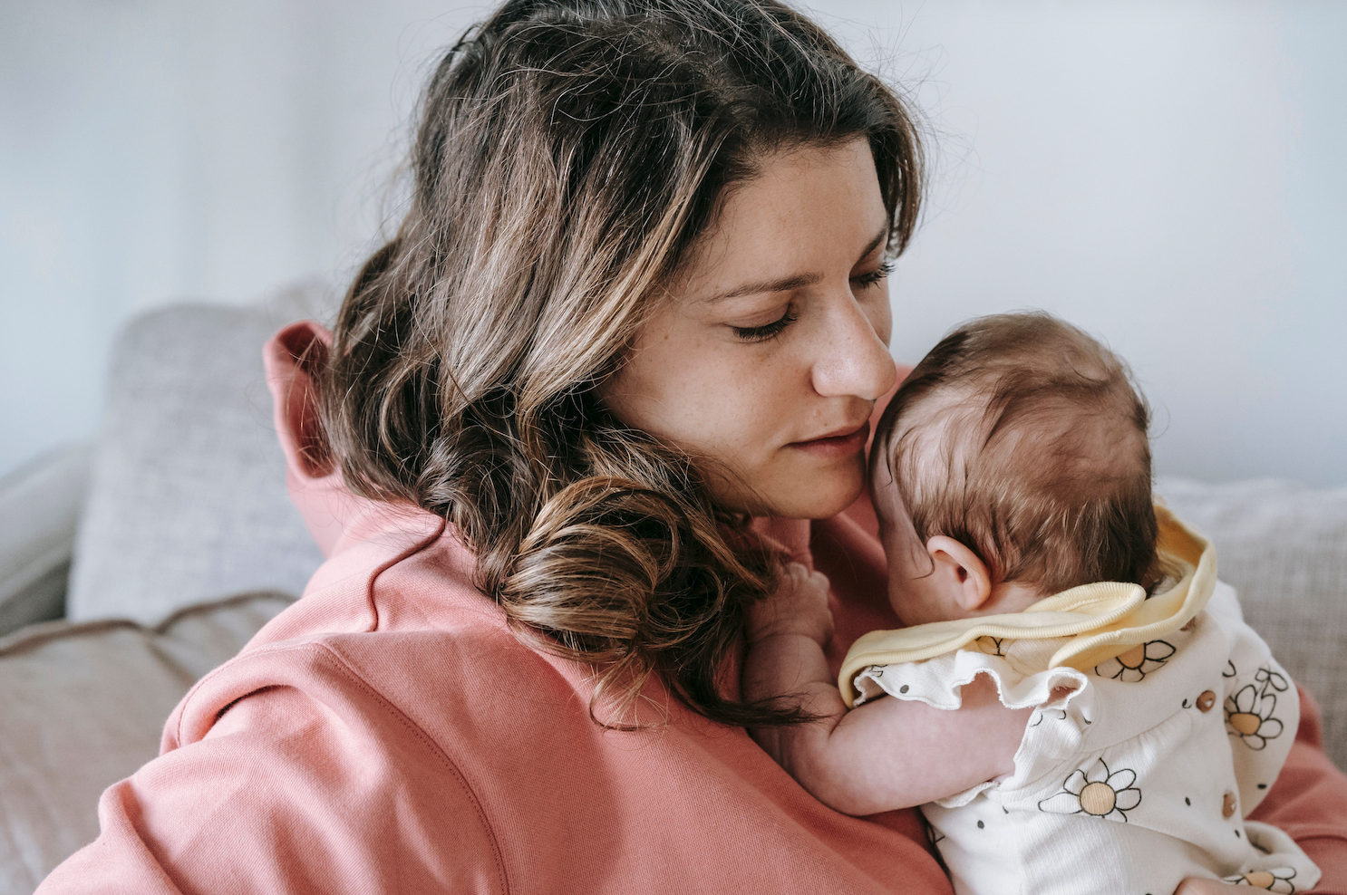 Tired mother with newborn on her chest