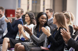 People clap and smile at each other at a conference